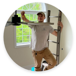 A man installing a ceiling fan.