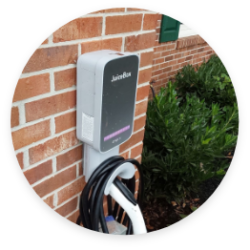 EV charger mounted on the outside of a brick house.