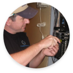 A man using tools to work on an open breaker box.